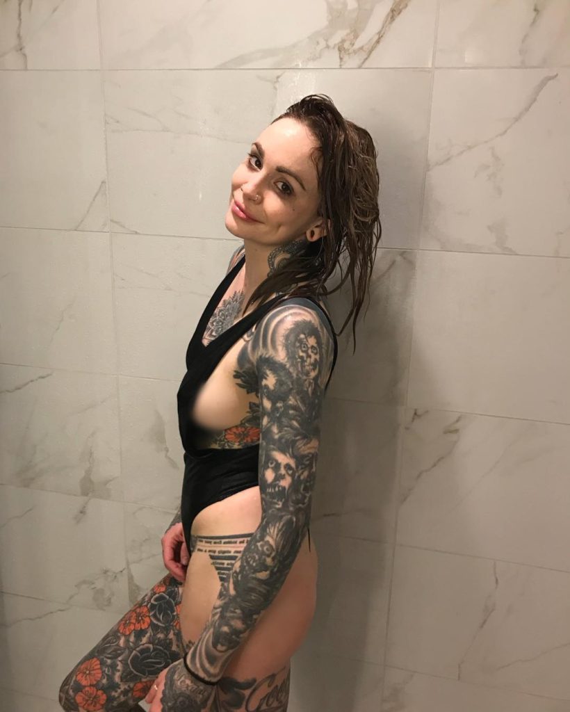 wet StripperWriter Elle Stanger in shower wearing swimsuit